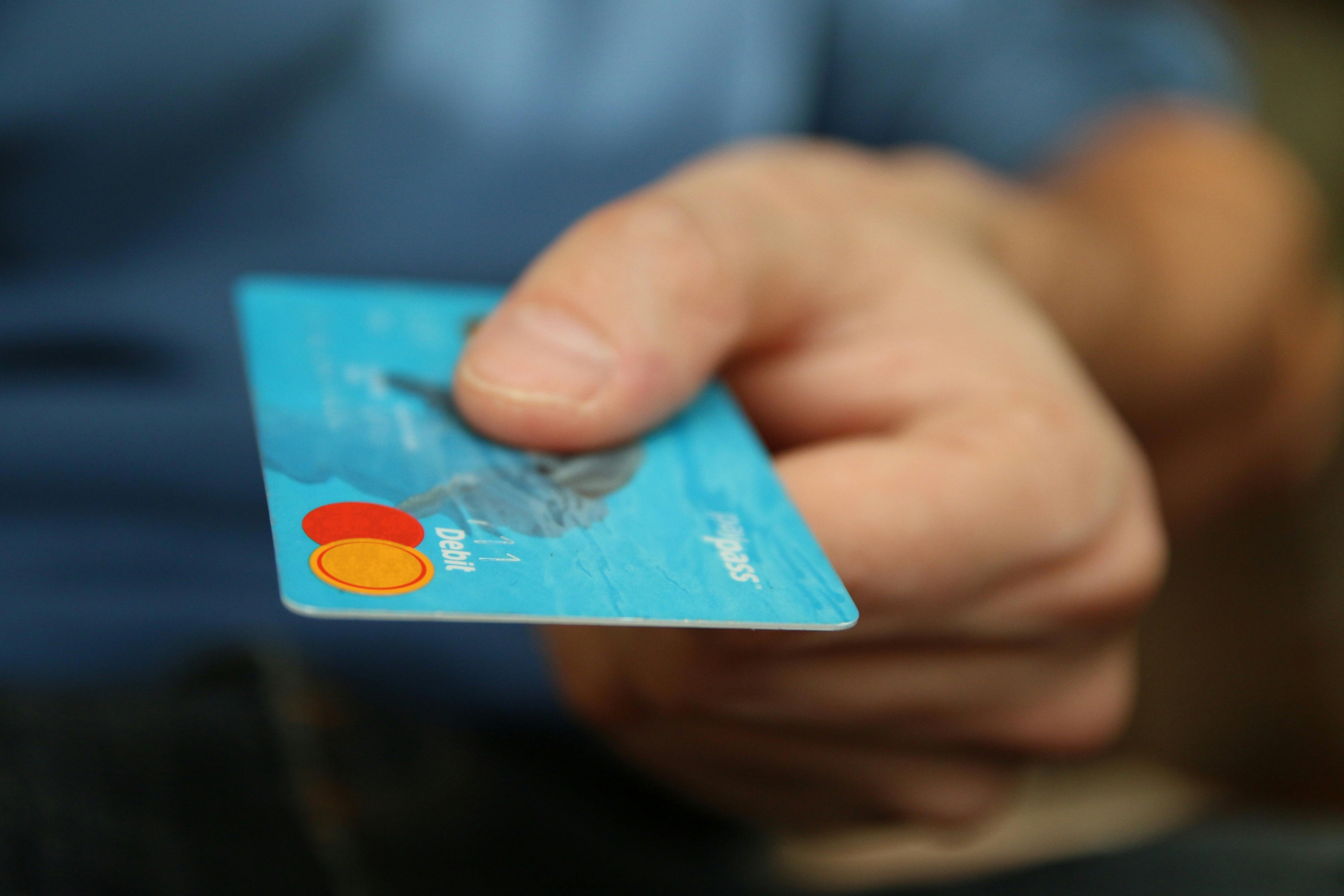 Man holds out credit card to pay for product